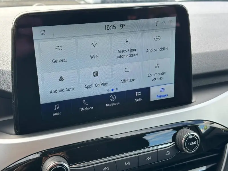 Écran tactile central du Ford Kuga 2024 gris Solar, affichant les réglages de connectivité et commandes vocales.