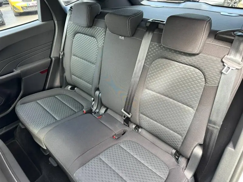 Vue de trois quarts arrière sur la banquette arrière noire matelassée du Ford Kuga 2024, avec ceintures et appuie-têtes.