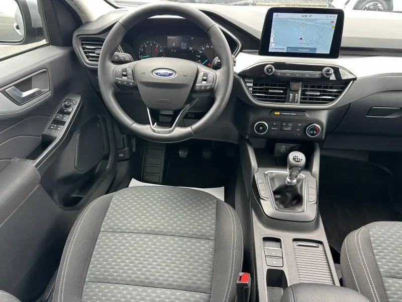 Vue intérieure avant centrée sur le volant cuir multifonction et la console avec écran tactile du Ford Kuga 1.5 EcoBoost gris Solar.