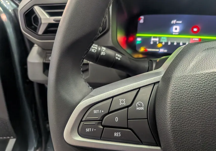Gros plan sur les commandes au volant du DACIA Bigster 2026, avec tableau de bord numérique en arrière-plan.