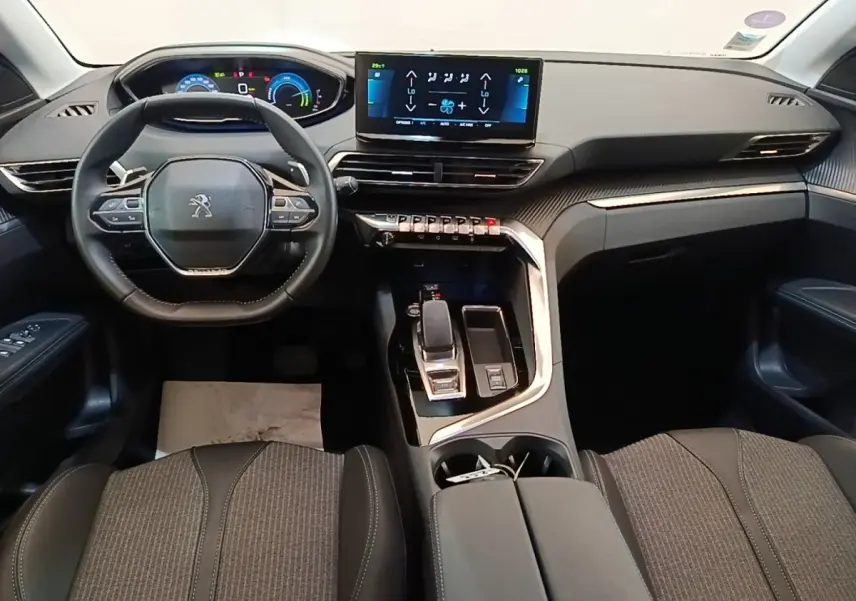 Vue intérieure du tableau de bord et volant cuir noir du Peugeot 3008 hybride rechargeable 2023, avec écran tactile central.