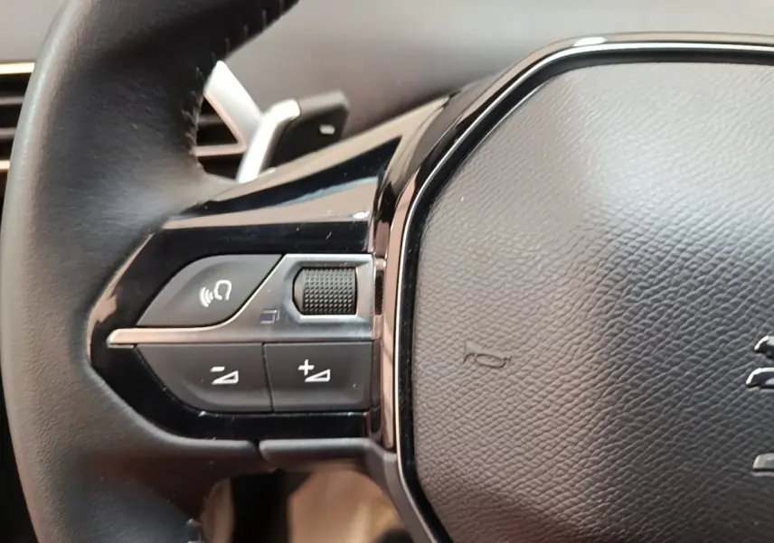 Gros plan sur le volant cuir multifonctions côté gauche du Peugeot 3008 hybride rechargeable 2023.
