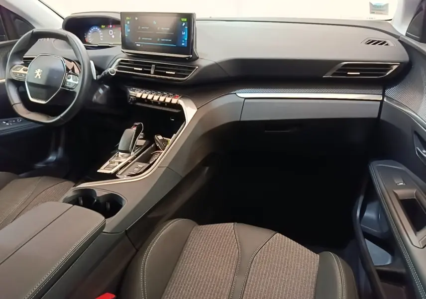 Intérieur avant droit du Peugeot 3008 bleu 1.6 HYBRID 225 Allure 2023, volant cuir et écran tactile central visible.
