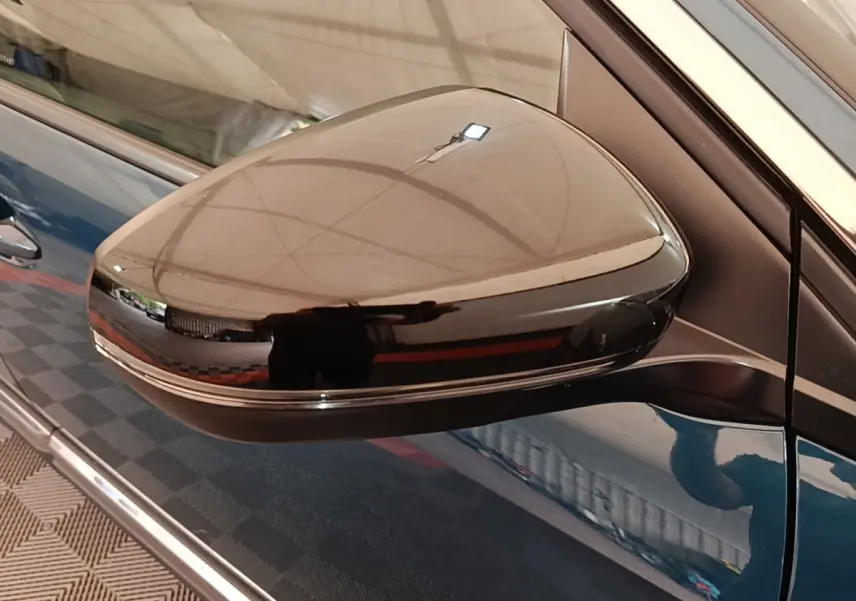 Rétroviseur droit noir brillant du Peugeot 3008 bleu hybride rechargeable, vue rapprochée côté conducteur.