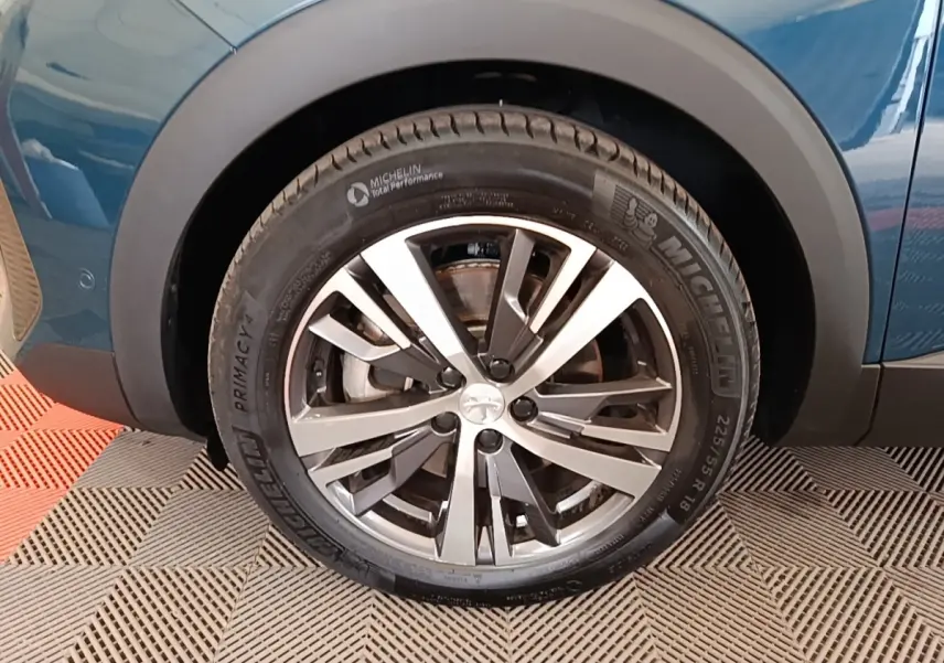 Gros plan sur la roue avant gauche du Peugeot 3008 bleu 2023 avec jante alliage et pneu Michelin.