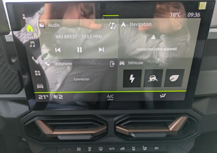 Écran tactile central du tableau de bord du Dacia Duster Hybrid 155 Extreme avec commandes climatisation et finition brun cuivré.