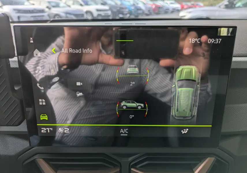 Écran tactile intérieur du Dacia Duster Hybrid 155 Extreme montrant les infos de conduite et la température à 21°C.