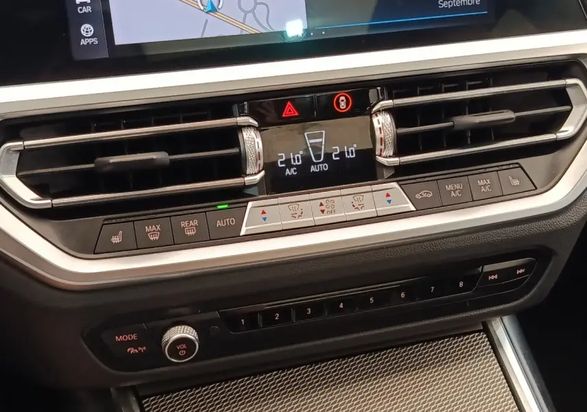 Détail du tableau de bord central de la BMW Série 3 320e M Sport 2022, avec commandes climatisation et écran tactile.