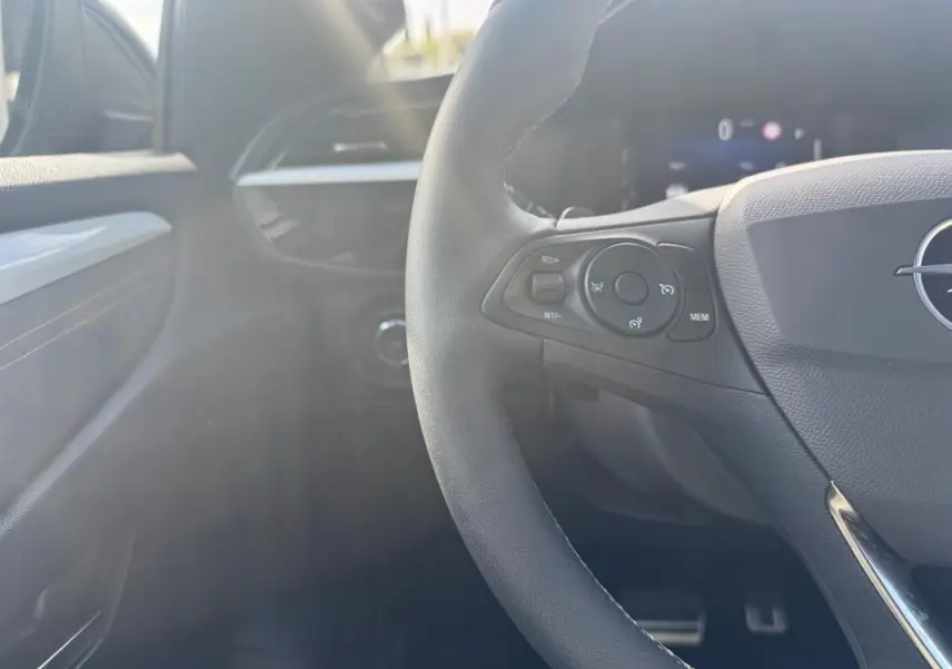 Intérieur noir d’une Opel Corsa 2025, vue rapprochée du volant avec commandes intégrées côté gauche.