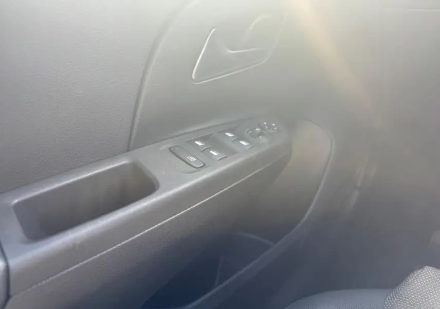 Gros plan sur la porte côté conducteur de l’Opel Corsa 1.2 Turbo Hybrid 2025 avec commandes de vitres et poignée noire.