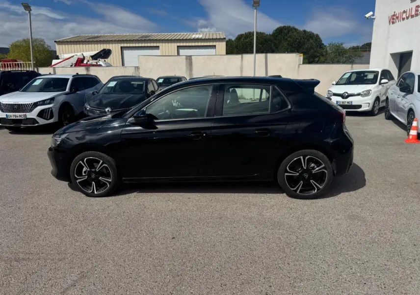 Opel Corsa 1.2 Turbo Hybrid 2025 vue de profil côté gauche, finition noire brillante avec jantes noires et argentées.