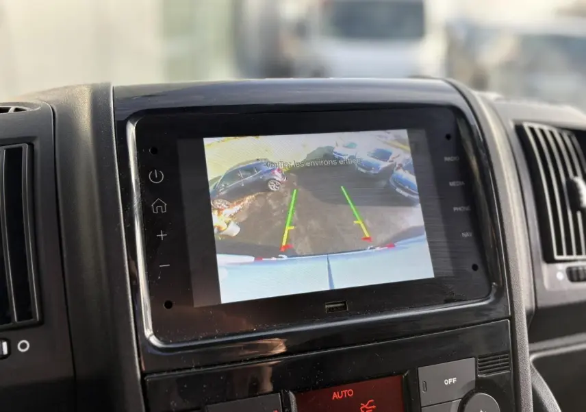 Écran de caméra de recul affichant l’arrière du fourgon blanc Opel Movano 2024, vue intérieure du tableau de bord.
