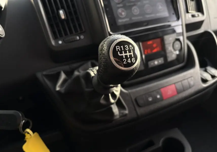 Gros plan sur le levier de vitesses manuel noir du tableau de bord d’un Opel Movano Fourgon blanc, 2024.