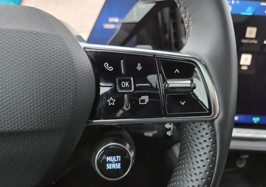 Gros plan sur les commandes gauche du volant du Renault Austral 2025 avec bouton Multi-Sense éclairé.