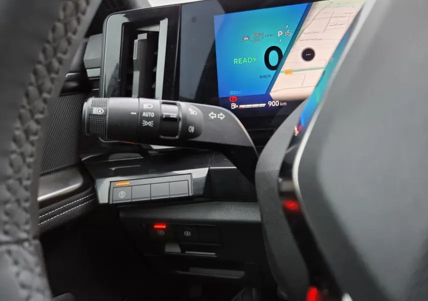 Vue rapprochée du tableau de bord et du commodo gauche du Renault Austral E-Tech, avec écran digital et commandes éclairage.