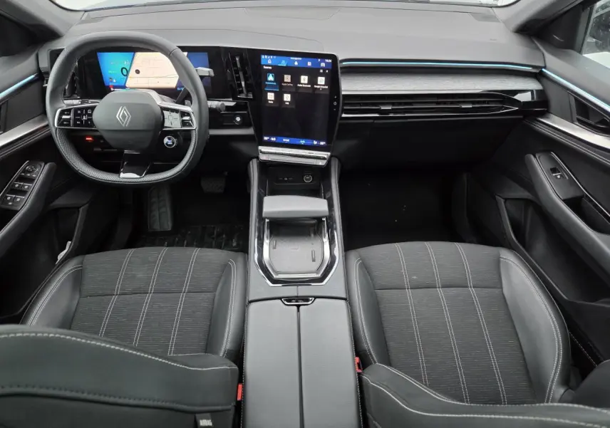 Vue intérieure avant du Renault Austral E-Tech 2025, tableau de bord moderne avec écran tactile vertical et volant compact noir.