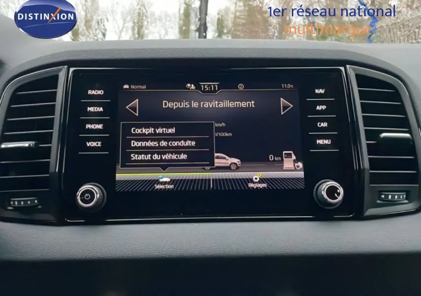 Écran central tactile du Skoda Karoq 2025 affichant les options de conduite, entouré de commandes noires.