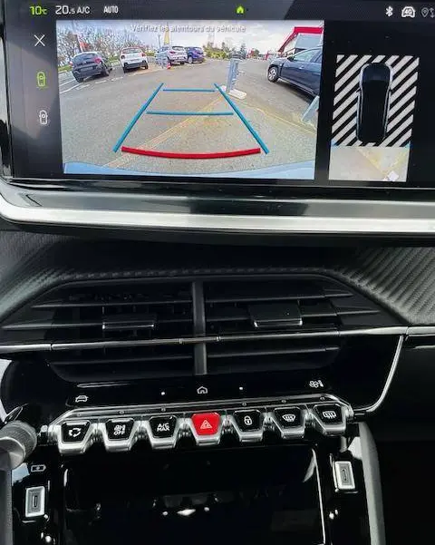 Vue de l'écran central du Peugeot 2008 GT 2024 montrant la caméra de recul avec guidage dynamique et tableau de bord noir.