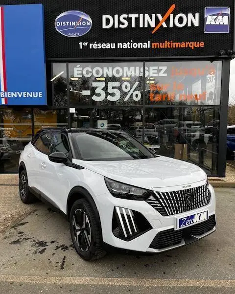 Peugeot 2008 PureTech 130 GT blanc en 3/4 avant droit, avec calandre distinctive et toit noir contrasté.