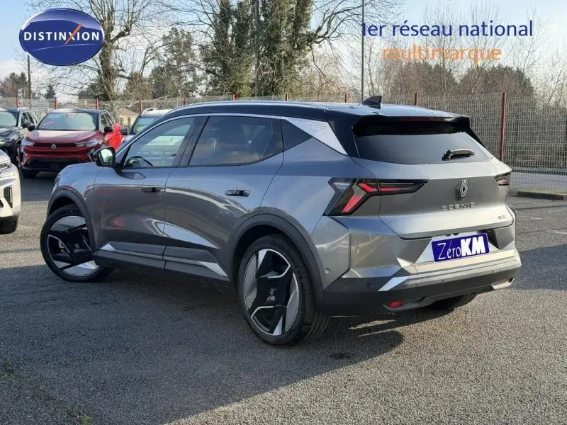 Vue 3/4 arrière droite du Renault Scénic E-Tech gris schiste avec jantes noires et vitres surteintées.