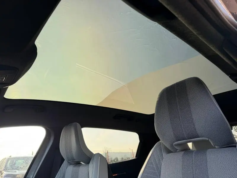 Intérieur du Renault Scénic E-Tech gris Schiste, vue sur sièges avant et toit panoramique en verre depuis l'arrière.