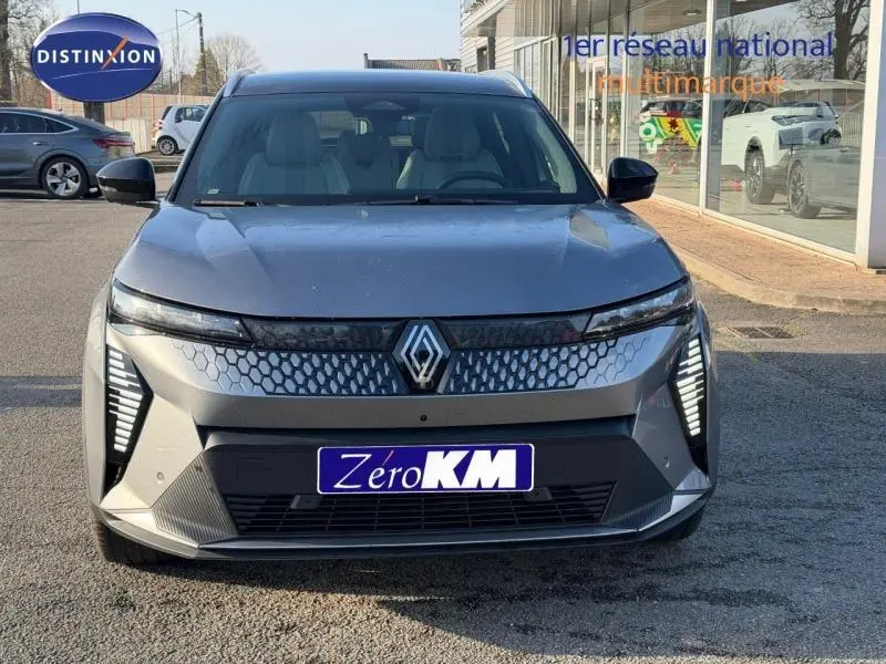 Vue frontale d'un Renault Scénic E-Tech électrique gris schiste avec calandre hexagonale et feux LED verticaux.