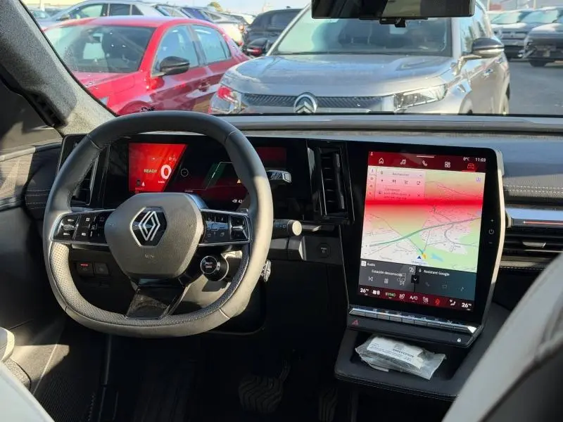 Vue intérieure du tableau de bord et volant Renault Scenic E-Tech 2025 avec écran tactile vertical et affichage numérique.