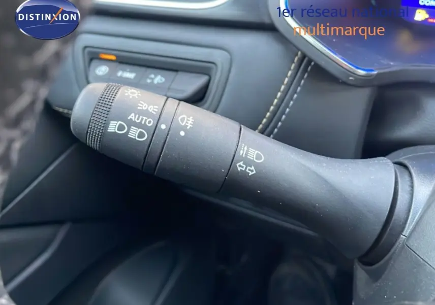 Gros plan sur la commande des feux et clignotants dans l’habitacle noir du Renault Symbioz gris cassiopée.