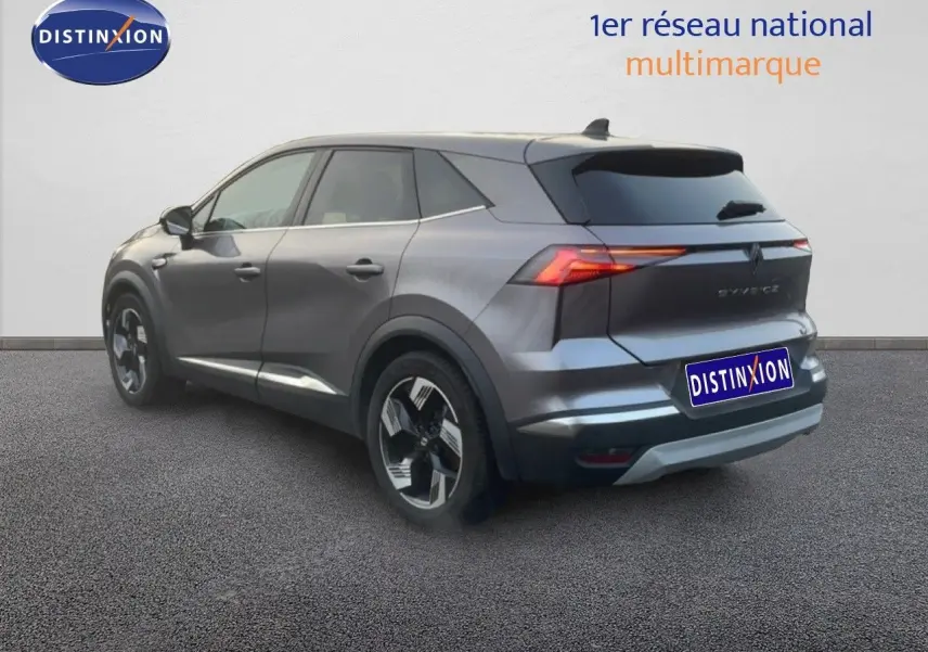 Vue 3/4 arrière droite d’un Renault Symbioz gris cassiopée métallisé avec feux arrière LED et jantes alliage.