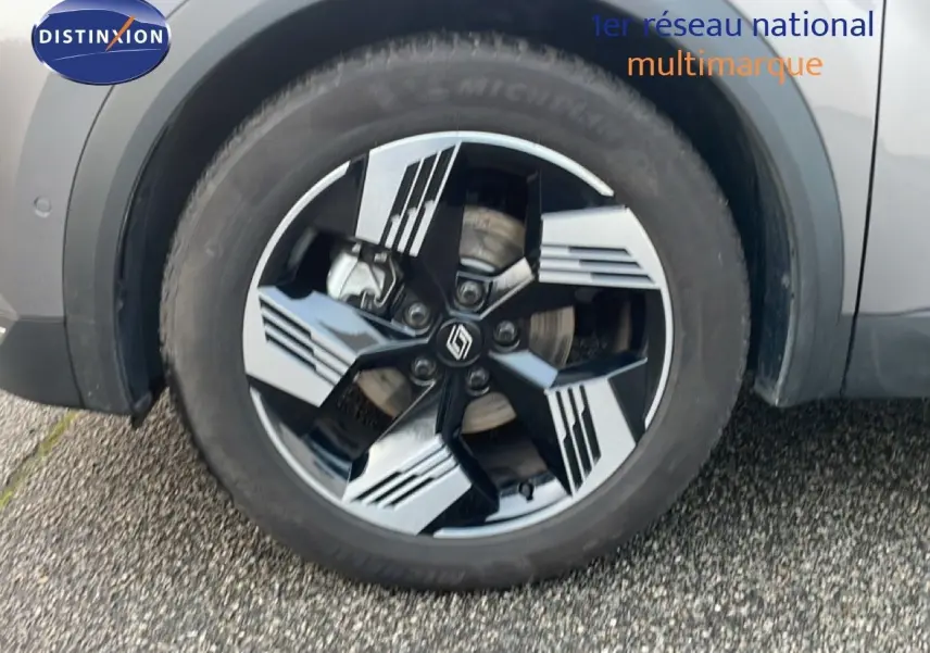 Gros plan sur la roue avant gauche gris cassiopée métal du Renault Symbioz avec jante noire et argentée au design géométrique.