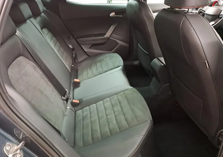 Vue intérieure côté arrière droit du SEAT Arona 2024, montrant les sièges arrière en tissu noir avec surpiqûres.