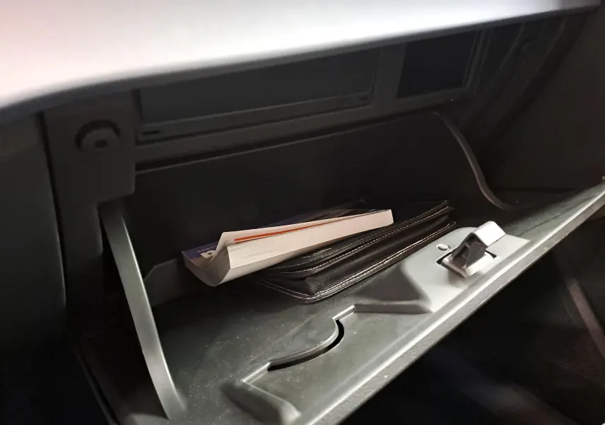 Gant de boîte à gants ouvert avec manuel et pochette noire à l'intérieur d'un SEAT Arona 2024.
