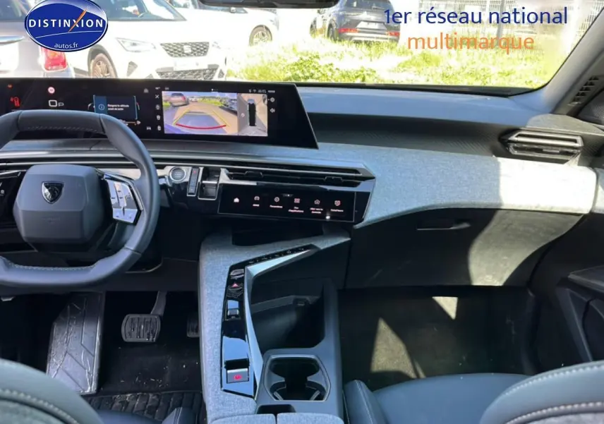 Vue intérieure avant du Peugeot 5008 Hybrid 145 allure e-dcs6 2025, tableau de bord moderne et volant cuir noir.