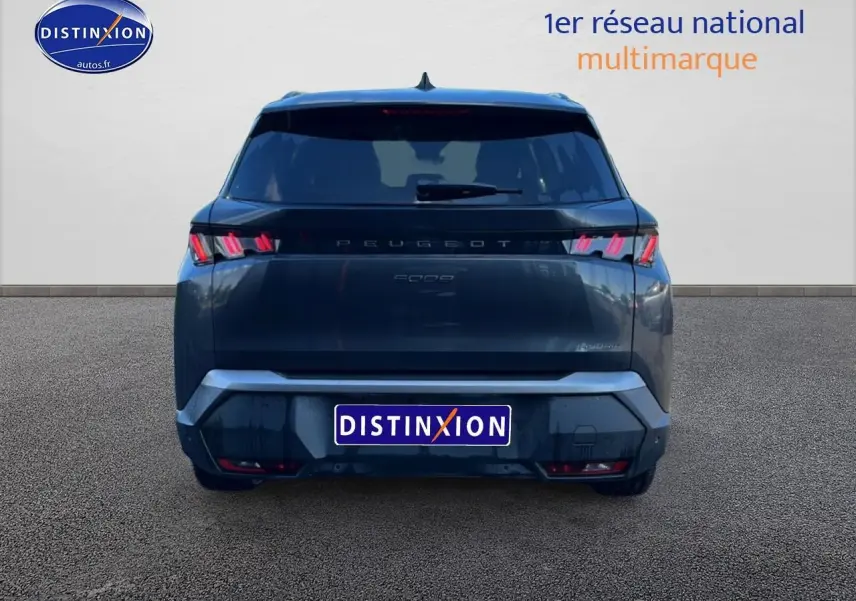 Vue arrière d'un Peugeot 5008 Hybrid 145 allure gris titane avec feux LED et becquet arrière visible.