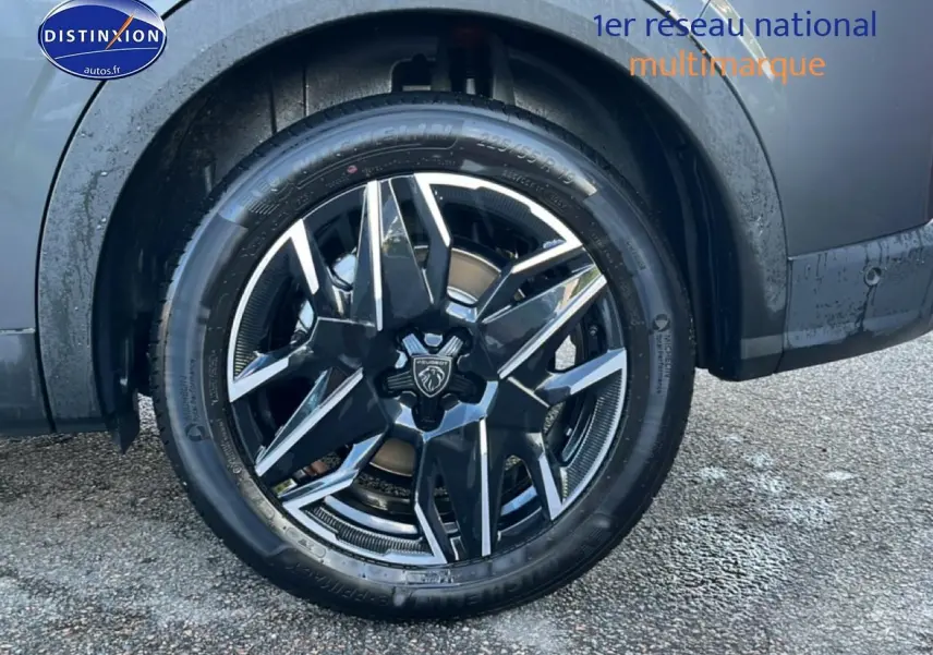 Gros plan sur la roue avant gauche avec jante alu noire et grise du Peugeot 5008 gris titane.