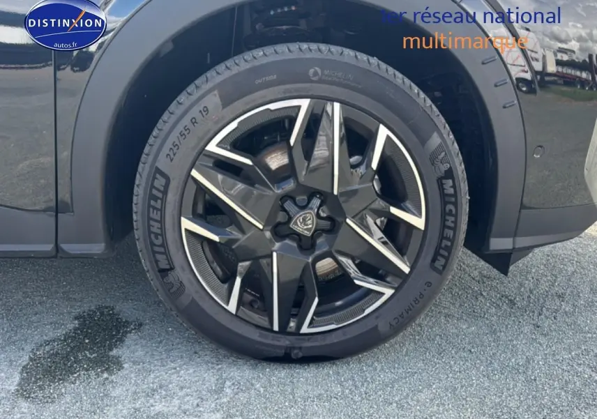 Gros plan sur la roue avant droite noire du Peugeot 5008 Hybrid 145 allure e-dcs6 avec jante alu stylisée.