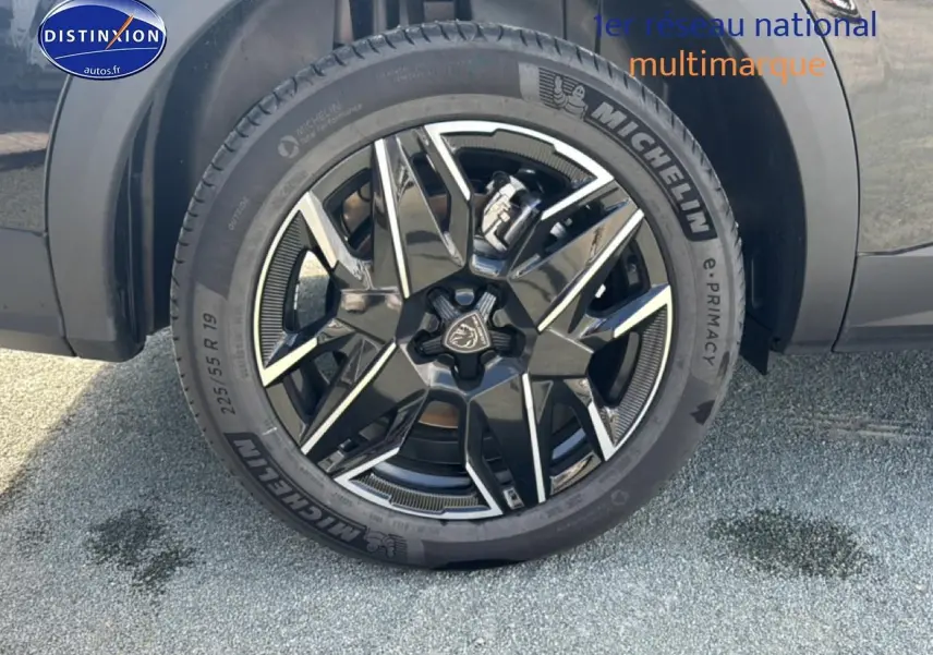 Gros plan sur la jante alu noire et argentée du côté gauche d’un Peugeot 5008 noir Hybrid 145 allure e-dcs6.