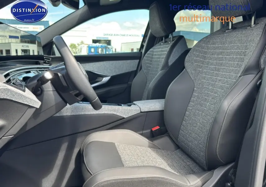 Vue intérieure côté conducteur du Peugeot 5008 Hybrid 145 allure 2025, sièges tissu gris et cuir noir.