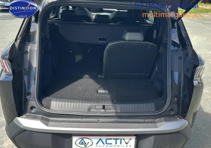 Coffre ouvert du Peugeot 5008 noir vu de l'arrière, montrant la banquette arrière partiellement rabattue et l'espace de chargement.