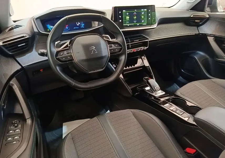 Intérieur Peugeot 2008 PureTech 130 2022 vu côté conducteur, tableau de bord moderne avec écran tactile et volant cuir multifonctions.