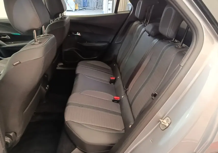 Vue intérieure côté droit des sièges arrière en tissu gris foncé du Peugeot 2008 gris clair, avec ceinture de sécurité rouge visible.