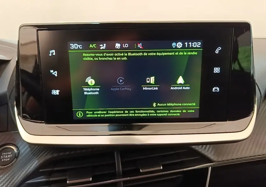 Écran tactile central du tableau de bord du Peugeot 2008 gris clair, affichant les options Bluetooth et Apple CarPlay.