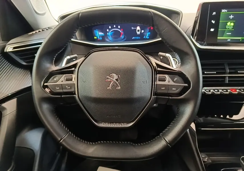 Volant cuir noir Peugeot 2008 2022 avec tableau de bord numérique et écran tactile central visible de face.