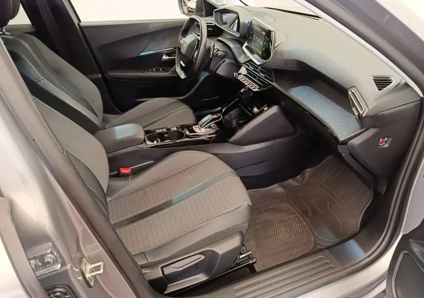Intérieur avant droit de la Peugeot 2008 gris clair 2022, avec tableau de bord moderne et écran tactile central.