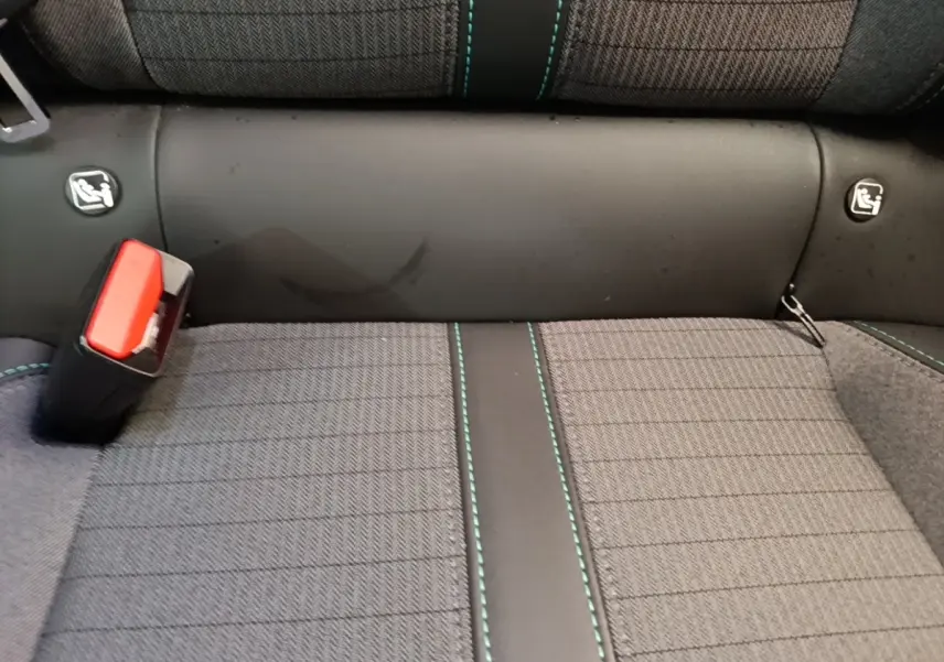 Gros plan sur la banquette arrière gris foncé avec coutures vertes et ceinture de sécurité rouge de la Peugeot 2008 2022.