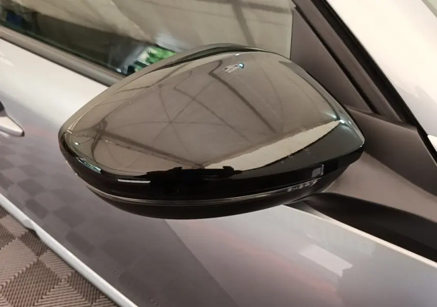 Rétroviseur extérieur noir en gros plan côté gauche sur Peugeot 2008 gris clair vue latérale.