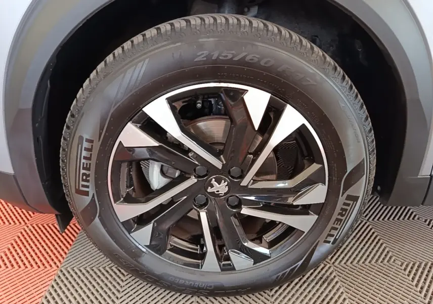 Gros plan sur la roue avant droite de la Peugeot 2008 gris clair, jante alliage noire et argent avec pneu Pirelli.