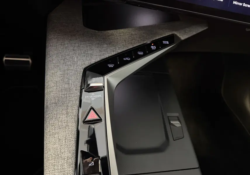 Vue rapprochée de la console centrale du Peugeot 3008 Hybrid 145 GT, soulignant les commandes tactiles sur fond tissu gris.