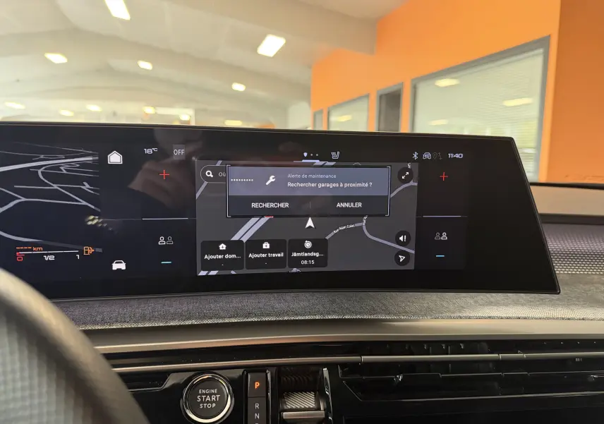 Vue intérieure du tableau de bord du Peugeot 3008 Hybrid 145 GT avec écran tactile affichant une alerte de maintenance.