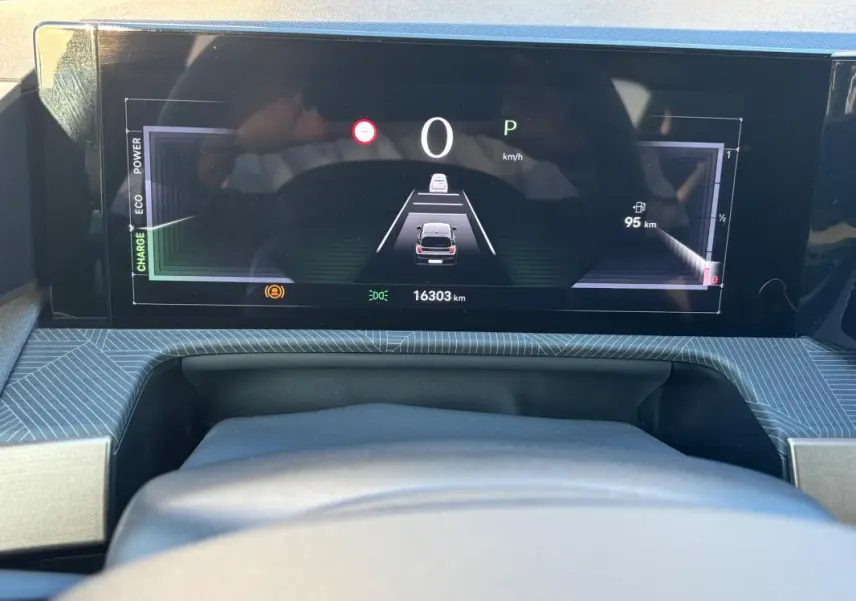 Vue intérieure du tableau de bord numérique de la Lancia Ypsilon gris, affichant la vitesse à zéro et l'autonomie restante.